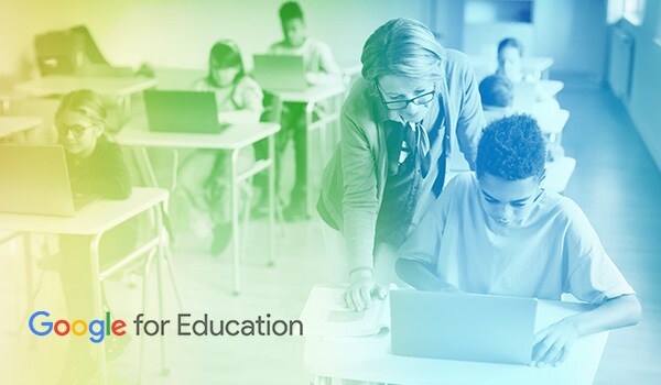 Google for Education - Teacher hunching over student's shoulder while he works on a laptop
