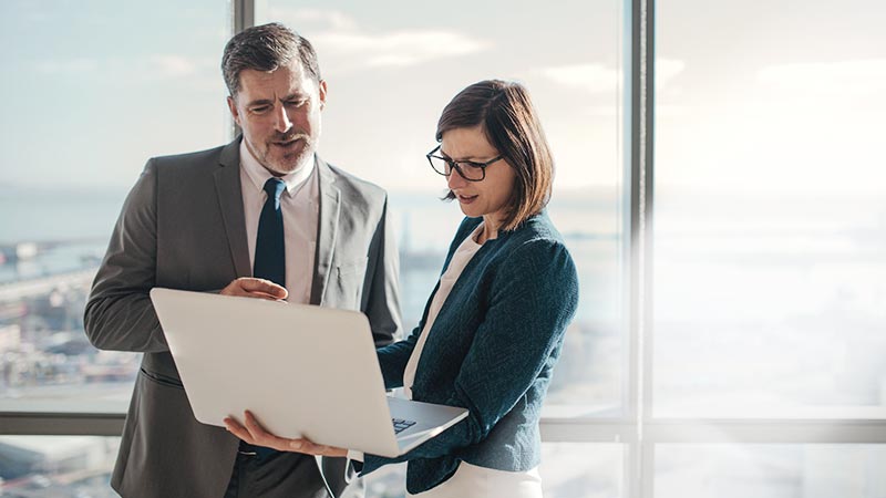 two people looking at a laptop